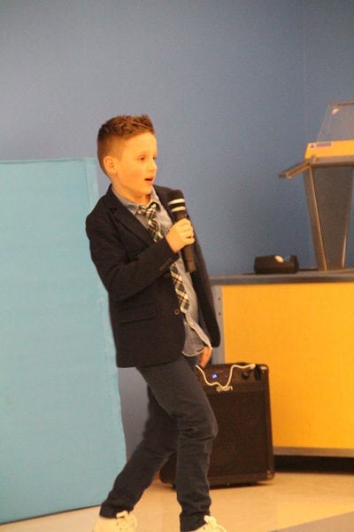 Student in Suit Singing at Talent Show